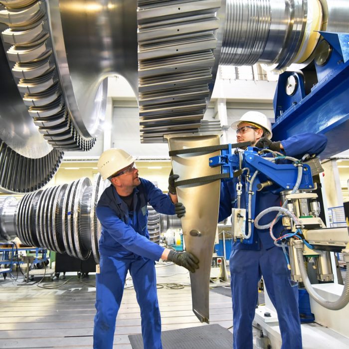 Workers assembling gas turbines workers assembling and constructing gas turbines in a modern industrial factory
