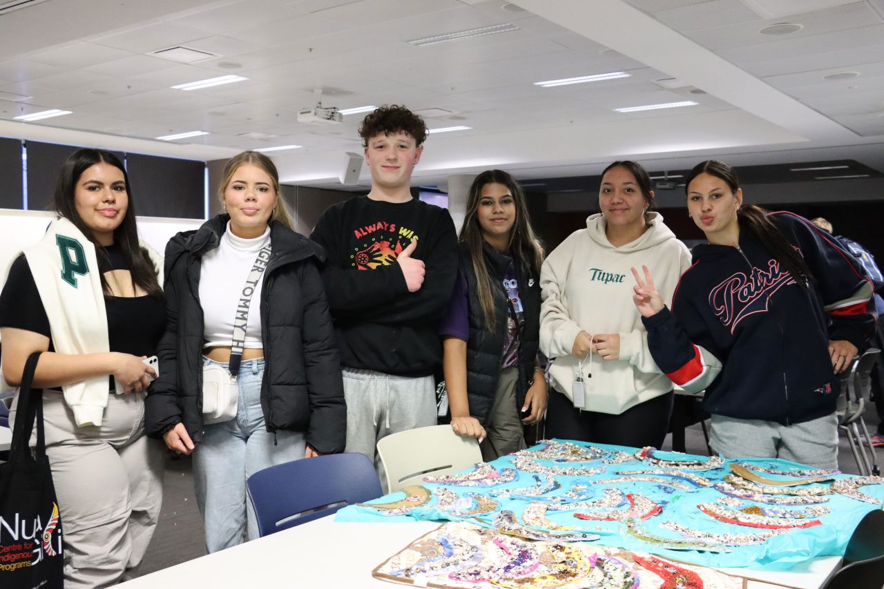 Nura Gili - Blak Hack students posing in group photo next to their project